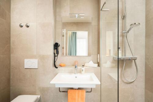 a bathroom with a sink and a shower at City-Hotel Aschaffenburg in Aschaffenburg