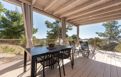 a patio with a table and chairs on a deck at Mobile home Azzurro in Drage