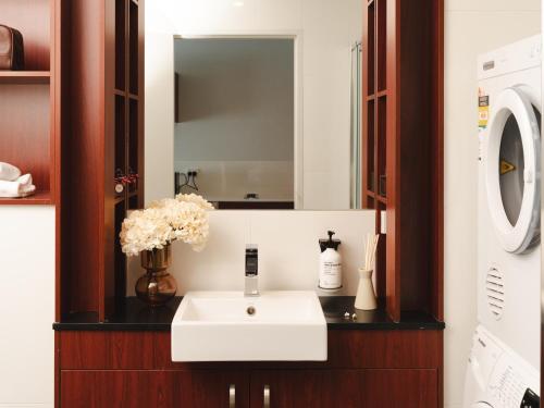 a bathroom with a white sink and a mirror at Punthill Narrabundah in Canberra