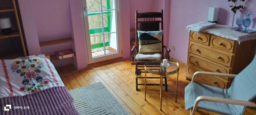 a bedroom with a bed and a dresser and a chair at Prawdzicówka in Zachełmie