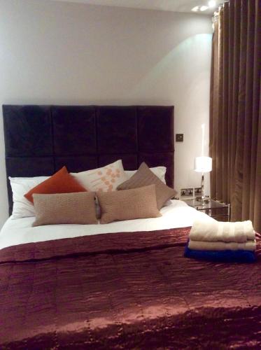 a bedroom with a large bed with a black headboard at Gunwharf Quays Harbour Apartments in Portsmouth