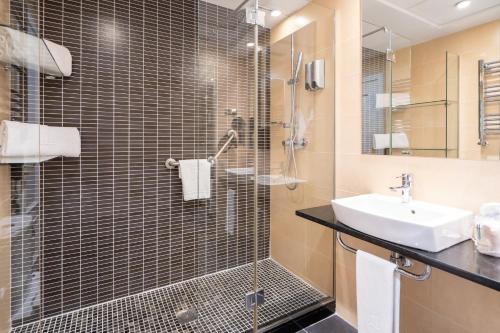 ein Badezimmer mit Glasdusche und Waschbecken in der Unterkunft Gran Versalles in Madrid