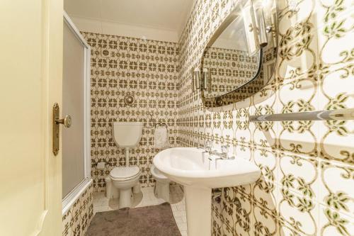 a bathroom with a sink and a toilet and a mirror at Excellent location, good access to the beach in Vila do Conde