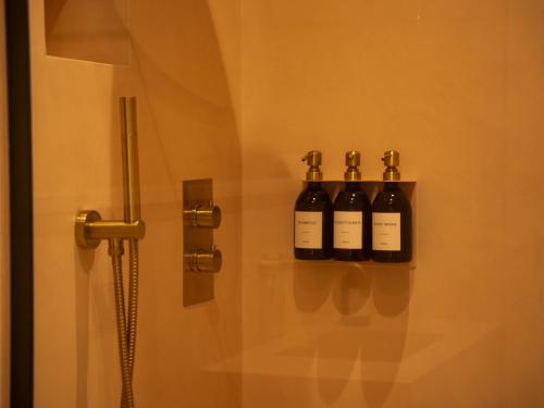 four bottles of wine on a wall in a bathroom at Yarn - Milo Deluxe King Suite in Ballycastle