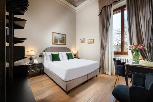 a hotel room with a white bed and a desk at Hotel Palazzo Borghini - Gruppo Estella Hotels in Florence