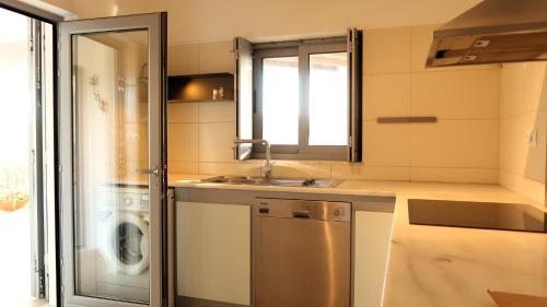 a kitchen with a sink and a washing machine at Herdade do Burrazeiro Turismo Rural no Alentejo in Borba