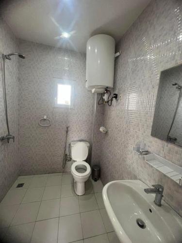 a bathroom with a toilet and a sink at MBAO Sipres Appartement moderne bord de mer in Mbaw