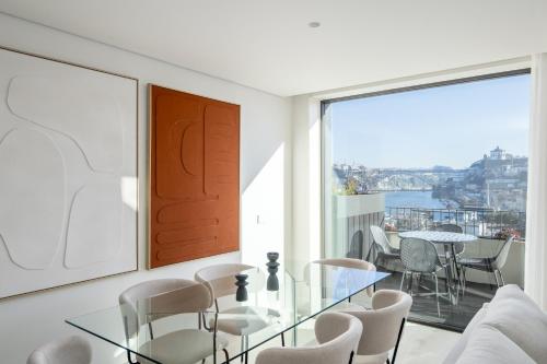 a living room with a glass table and chairs at Land Roots Riverside Apartments in Vila Nova de Gaia