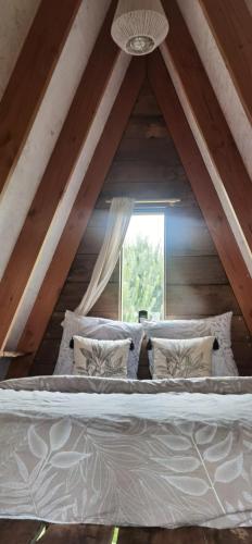 a large bed in a room with a window at La Kabanetik in La Tacherie