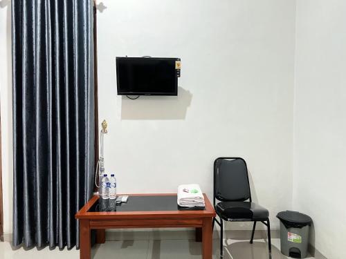 a room with a desk and a television and a chair at Guest House Primitif in Temon