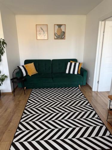 a green couch in a living room with a black and white rug at Cozy Apartment In Sigulda in Sigulda