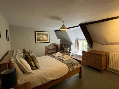 a bedroom with a bed and a dresser and a window at Ivy Cottage in West Lulworth