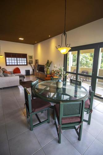 a living room with a glass table and chairs at Vila_da_Montanha in Gravatá