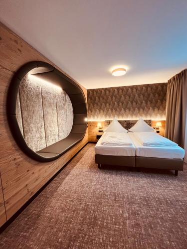 a bedroom with a bed and a large mirror at Hotel Waldmühle in Zella-Mehlis