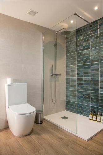 a bathroom with a toilet and a glass shower at Casa Rural La Posada del Quijote in Puerto Lápice