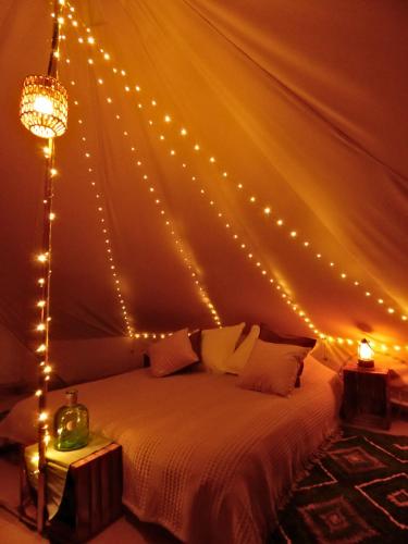 a bedroom with a bed with lights on it at Nid et Toiles in Bernadets-Debat