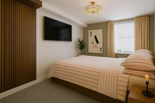 a bedroom with a bed and a flat screen tv at The Cask Room in Scarborough