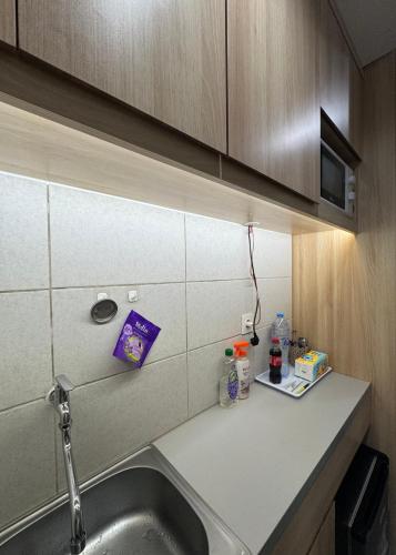 a kitchen counter with a sink and a microwave at Osaka riverview Apartment PIK 2 by SS in Rawalumpang