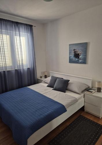 a bedroom with a large bed and a window at Apartment Perla in Dinjiška