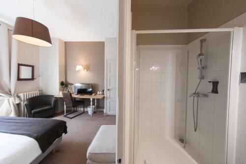 a hotel room with a bed and a shower at Hotel Mondial in Tours