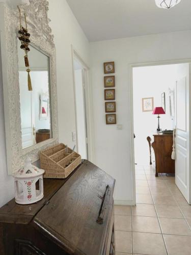 a room with a mirror and a wooden table at L'appartement la rochebardière in Saint-Paul-lès-Dax