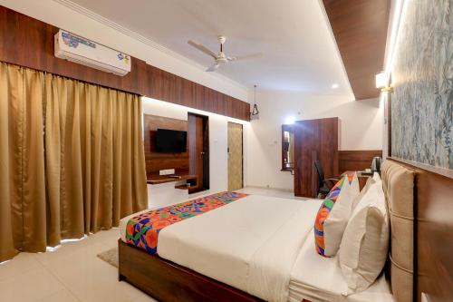 a bedroom with a large bed and a television at FabHotel High Five - Nr Vagator Beach in Assagao