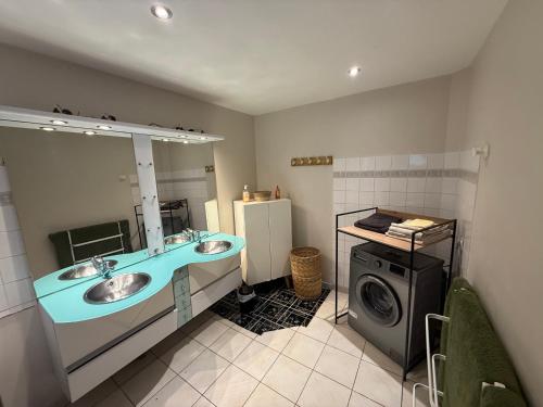a bathroom with two sinks and a washing machine at Appartement moderne avec jardin, quartier calme in Saint-Claude
