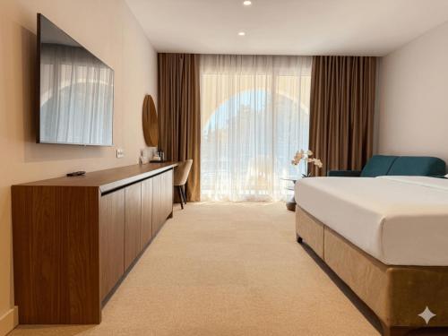 a hotel room with a bed and a large window at Hotel Riva in Budva