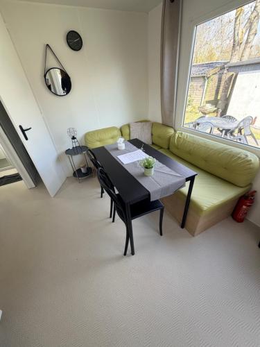 a living room with a table and a green couch at Strand chalet Makkum in Makkum
