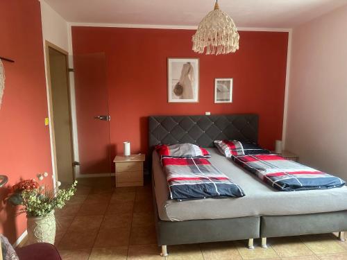 a bedroom with a bed in a red wall at Ferienwohnung am Nurburgring in Welcherath