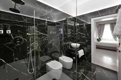 a black bathroom with a toilet and a sink at Hotel Palazzo Borghini - Gruppo Estella Hotels in Florence
