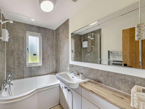 a bathroom with a tub and a sink and a mirror at 2 Bed in Crewe oc-83192 in Audlem