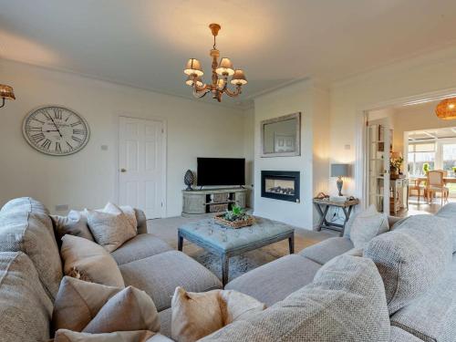a living room with a couch and a clock on the wall at 3 Bed in Maryport oc-82438 in Dearham