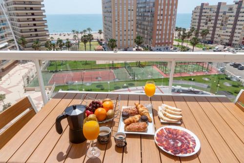 a tray of breakfast food on a table on a balcony at Cullera Playa Racó in Cullera