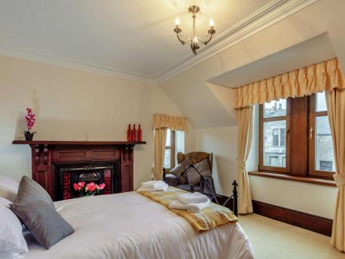 a bedroom with a bed with a fireplace and a chandelier at 3 Bed in Buckie oc-89824 in Buckie