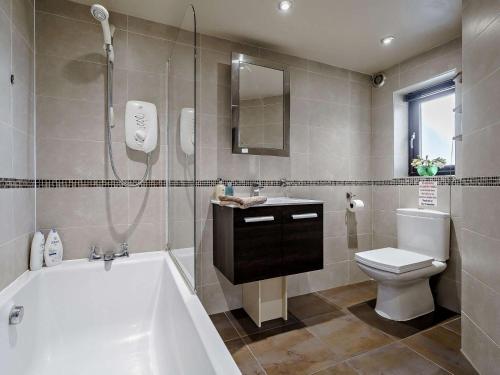 a bathroom with a tub and a toilet and a shower at 2 Bed in Blackburn oc-finch in Blackburn