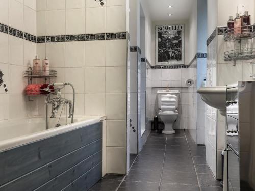 a bathroom with a tub and a sink and a toilet at 2 Bed in Grange Over Sands oc-lcc01 in Grange Over Sands