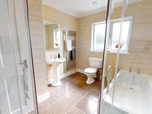 a bathroom with a tub and a toilet and a sink at 3 Bed in Onich oc-ca159 in Onich