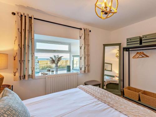 a bedroom with a bed and a large window at 4 Bed in Wick oc-95612 in Huna