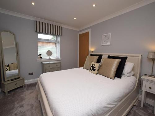 a bedroom with a large white bed and a mirror at 1 Bed in Glasgow oc-83392 in Eaglesham