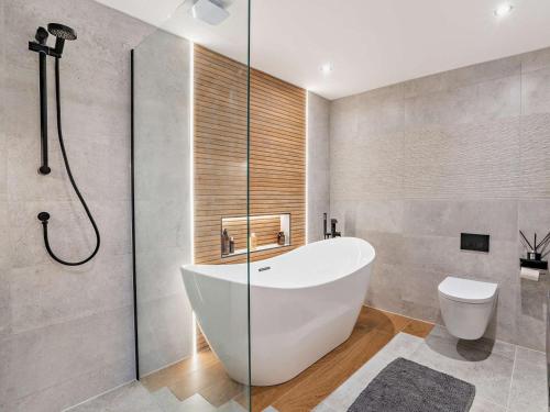 a bathroom with a tub and a toilet and a shower at 1 Bed in Glasgow oc-83392 in Eaglesham