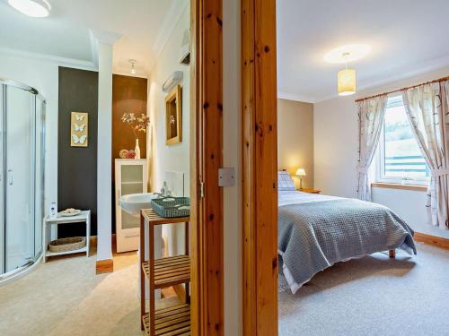 a bedroom with a bed and a bathroom with a sink at 1 Bed in Beauly oc-82779 in Beauly