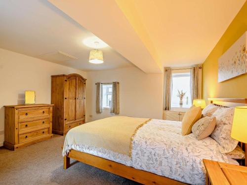 a bedroom with a bed and a dresser and a window at 2 Bed in Bonnybridge oc-90602 in Bonnybridge