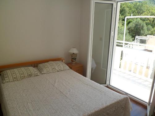 ein Schlafzimmer mit einem Bett und einem großen Fenster in der Unterkunft Milocer Apartment in Sveti Stefan