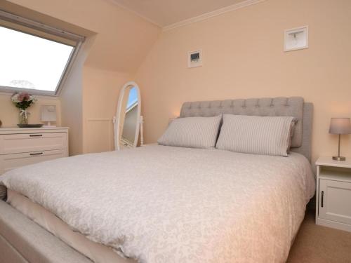 a bedroom with a large white bed with a window at 3 Bed in Galashiels oc-76698 in Galashiels