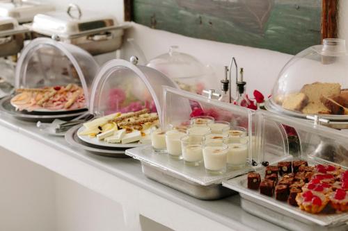 a buffet with many different types of desserts and pastries at Oia Mare Villas in Oia