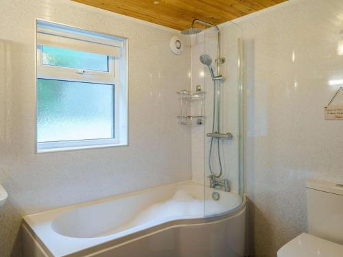 a white bathroom with a tub and a window at 3 Bed in Keswick oc-86613 in Threlkeld