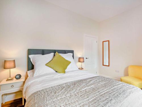 a bedroom with a large bed and a yellow chair at 1 Bed in Hawick oc-88731 in Hawick