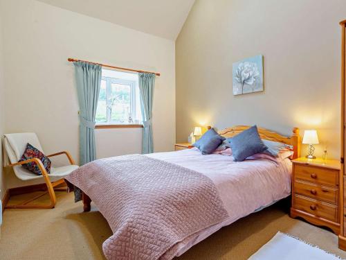 a bedroom with a bed and a chair and a window at 1 Bed in Beauly oc-82778 in Beauly