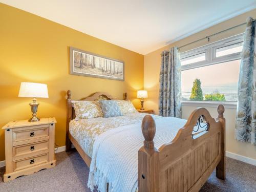 a bedroom with a wooden bed and a window at 2 Bed in Bonnybridge oc-95833 in Bonnybridge
